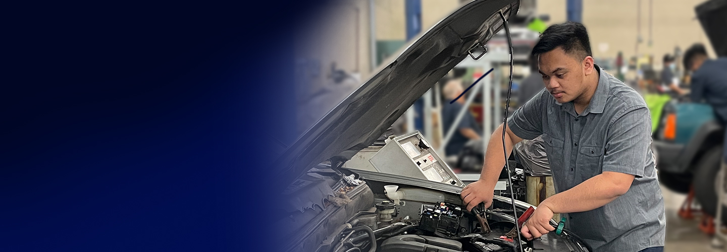 automechnanics student checking a car battery