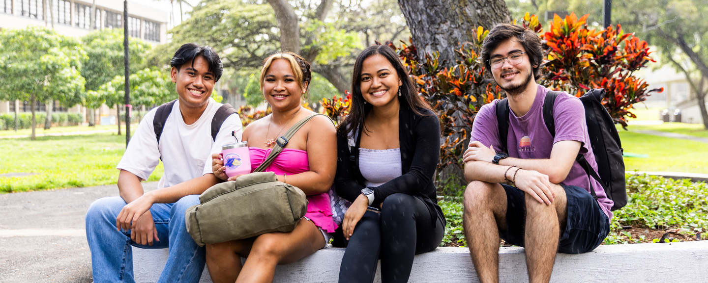 2 male and 2 female students sitting on a bench