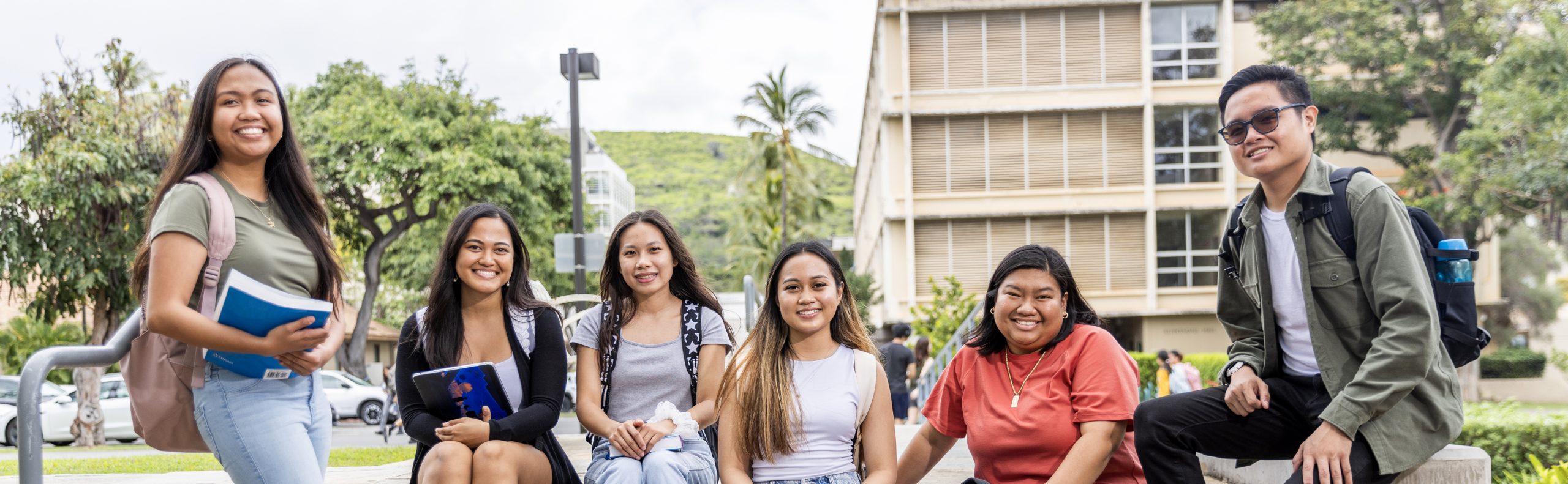 6 students (5 females and 1 male) sitting on bench